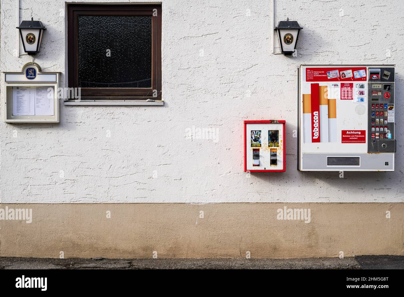 Ein Kaugummi-Automaten und ein Zigarettenautomaten an der Wand eines Mittelklassestaurants. Stockfoto