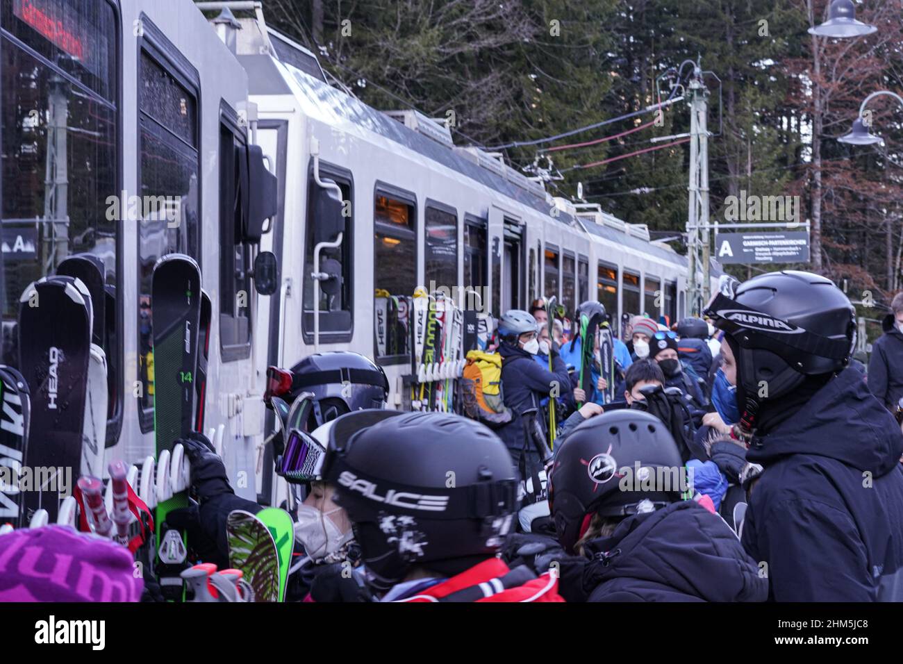 Zahlreiche Skiurlauber, die Corona-Masken tragen, sind mit ihren Skiern an einem Zug am Bahnhof Eibsee (Zugspitze) sehr voll. Stockfoto