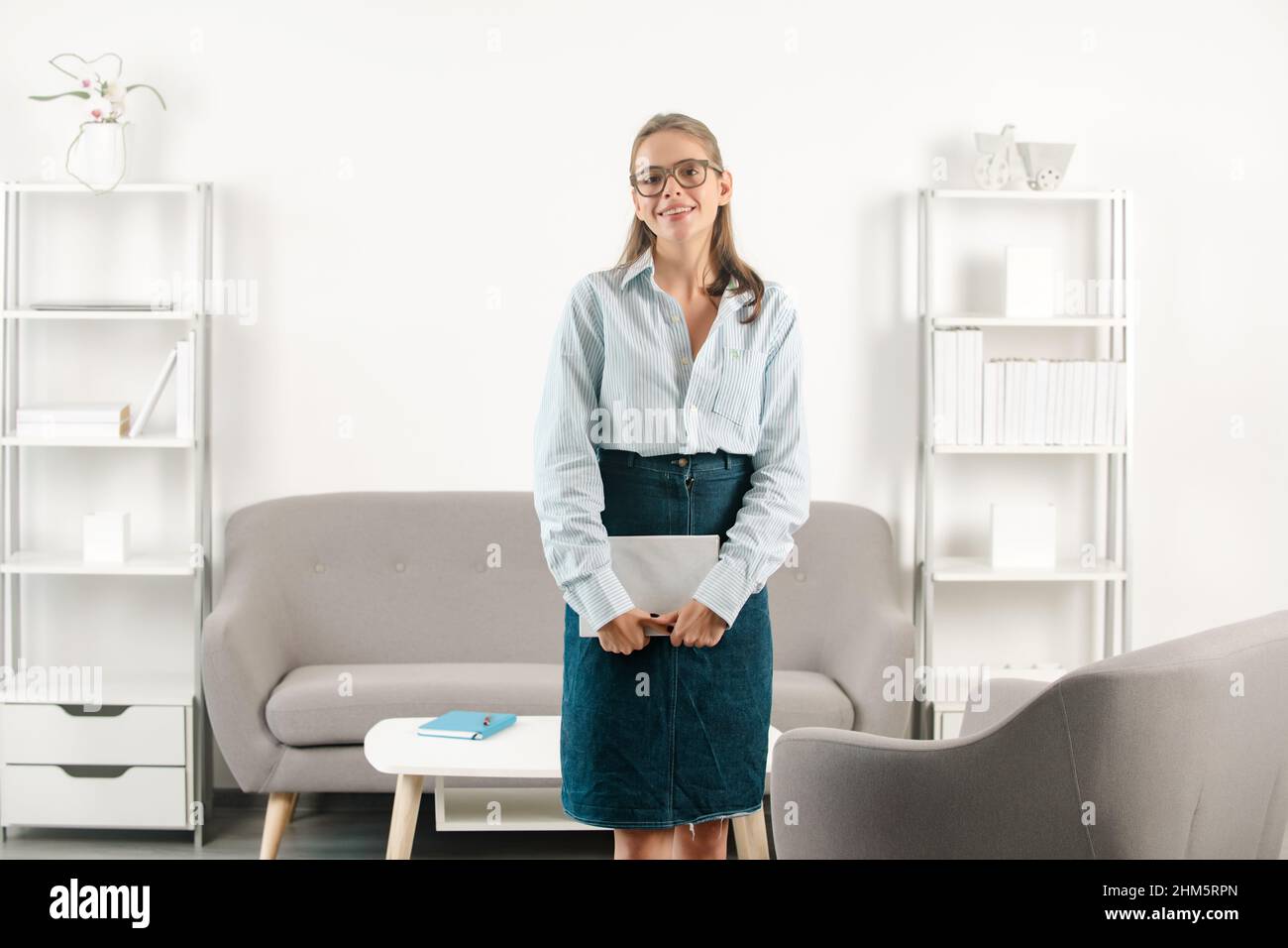 Porträt einer jungen Geschäftsfrau, Buchhalterin in formeller Kleidung am Arbeitsplatz im Büro. Erfolgreiche Managerin mit Notizbuch oder Notizblock, wunderschön Stockfoto
