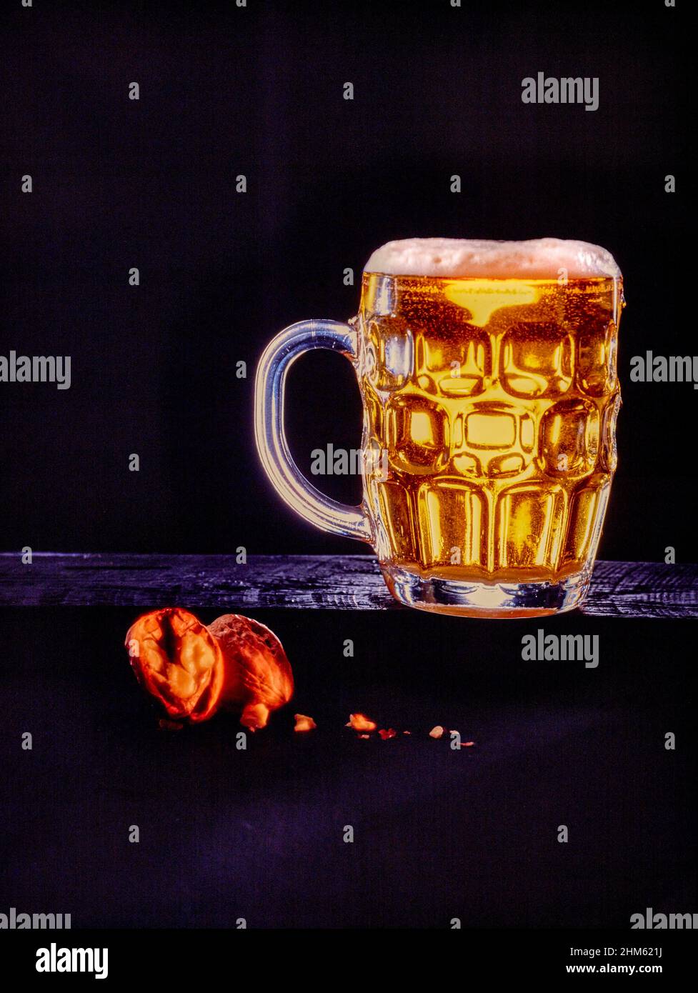 Trinken Sie das Stillleben von Bier in einem Pint Glas mit Walnüssen Stockfoto