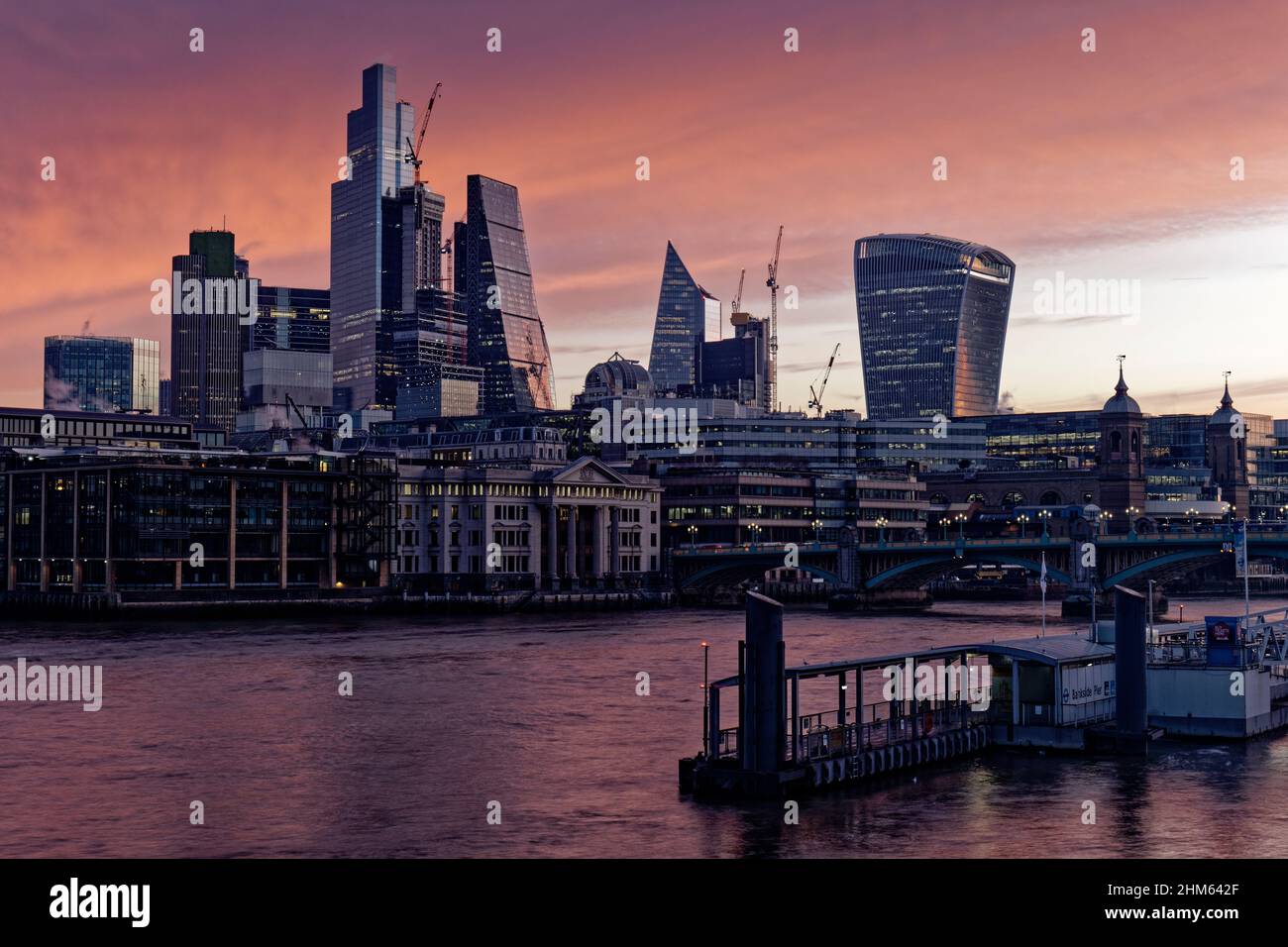 Der zentrale Bereich des Londoner Finanzviertels mit seinen verschiedenen Hochhäusern und Wolkenkratzern taucht bei Sonnenaufgang an einem kühlen Morgen aus der Dunkelheit auf Stockfoto
