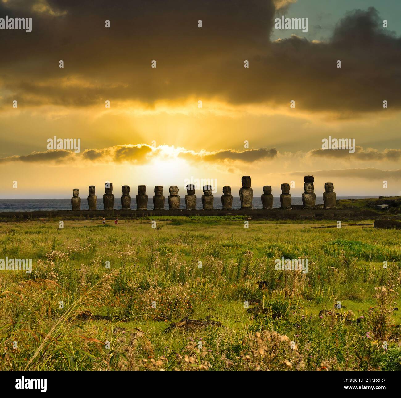 Moai-Statuen auf der Osterinsel, beleuchtet von einem dramatischen Sonnenuntergang Stockfoto