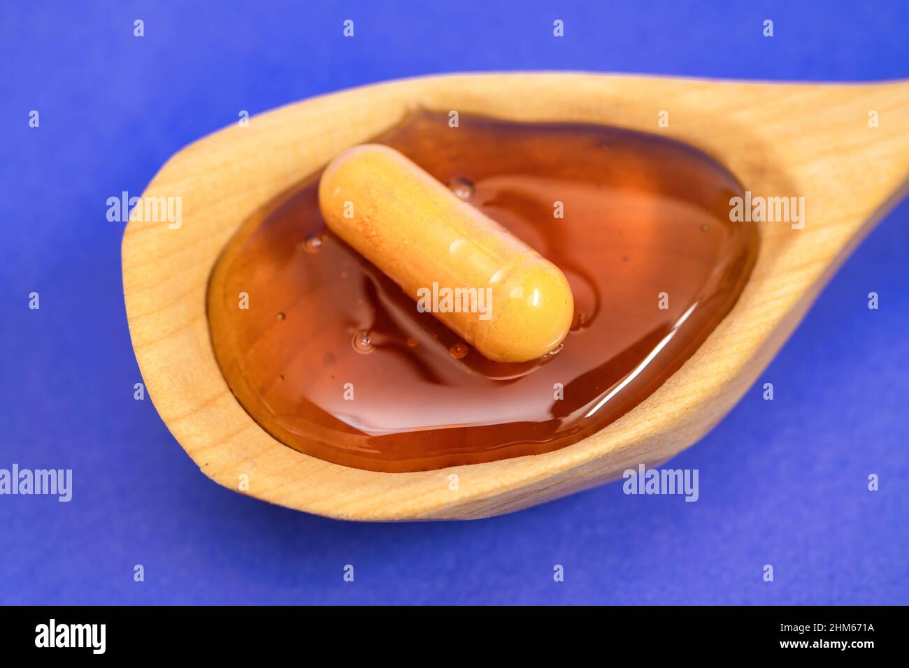 Konzept der natürlichen Medizin, eine Pille über Honig gesehen Stockfoto