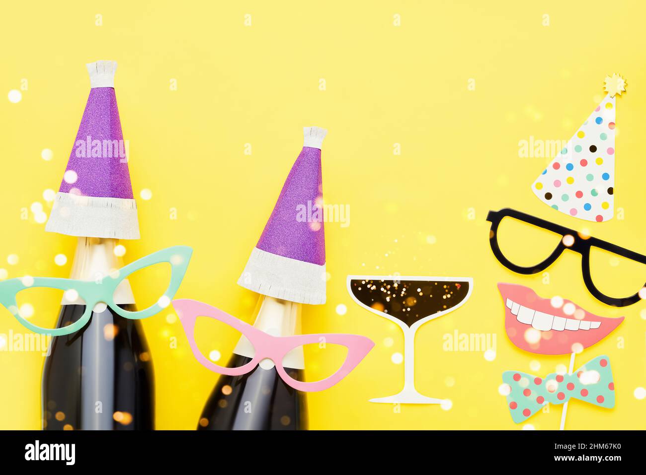 Karnevalskonzept. Feiertagshintergrund mit Party-Requisiten, Masken und Champagner auf hellgelbem Hintergrund. Draufsicht, Platz für Text kopieren Stockfoto
