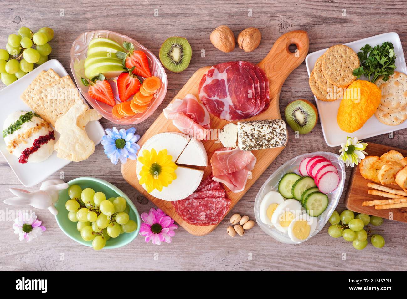 Frühling oder Ostern Thema Charcuterie Tischszene vor einem Holzhintergrund. Verschiedene Vorspeisen mit Käse, Fleisch, Obst und Gemüse. Draufsicht. Stockfoto