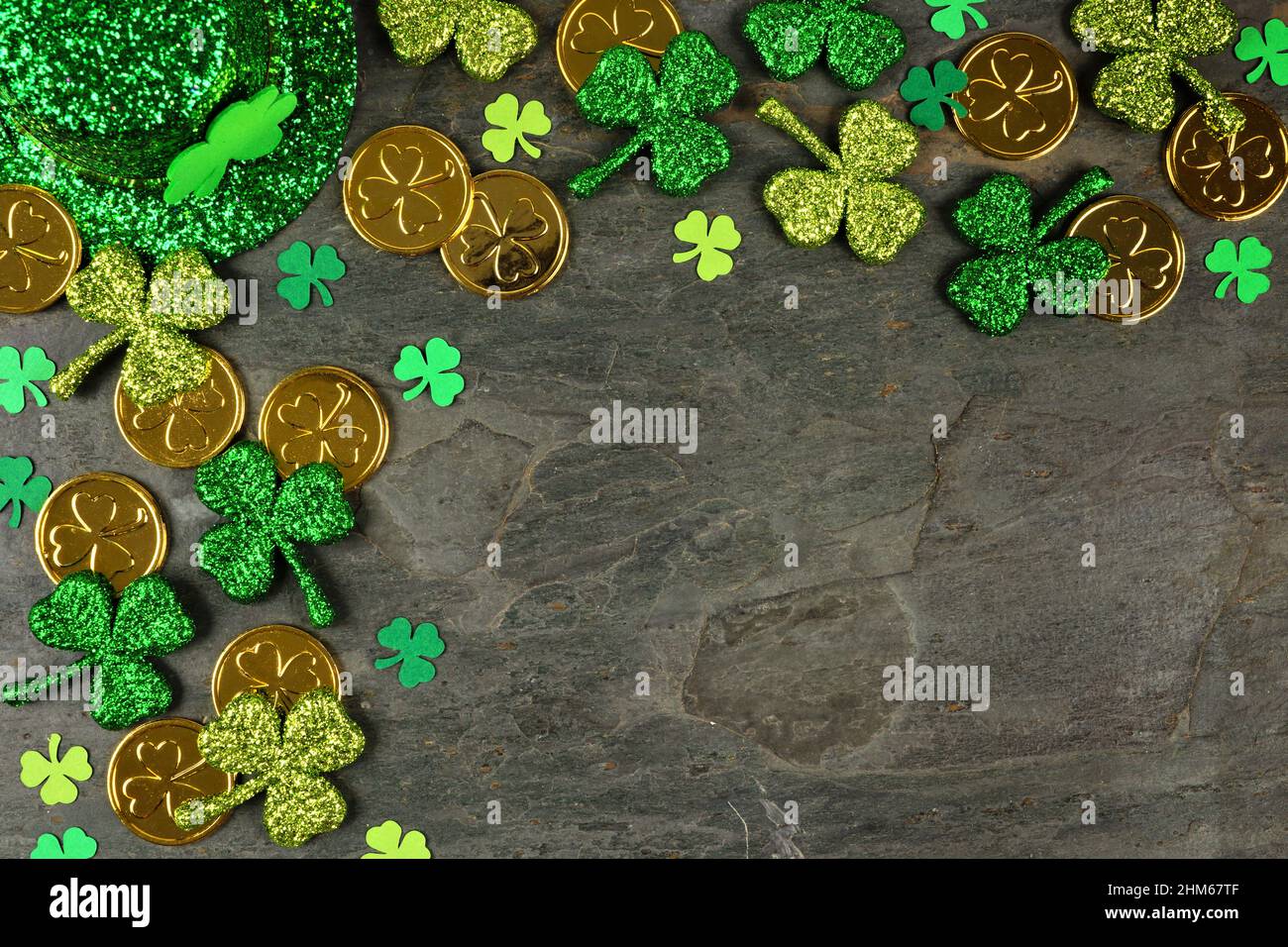 St. Patricks Day Ecke Grenze mit Schamhacken, Goldmünzen und Kobold Hut über einem dunklen Schieferhintergrund Stockfoto
