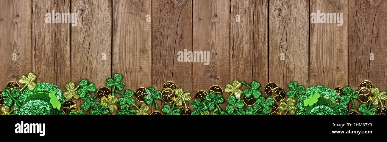 St. Patricks Day Banner mit Rand aus Schamanen, Goldmünzen und Kobold Hut. Blick über einen rustikalen Holzhintergrund. Speicherplatz kopieren. Stockfoto