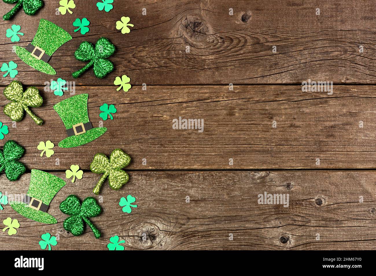 St. Patricks Day Kleeblatt und Kobold Hut Seitenrand. Blick über einen rustikalen Holzhintergrund mit Kopierraum. Stockfoto