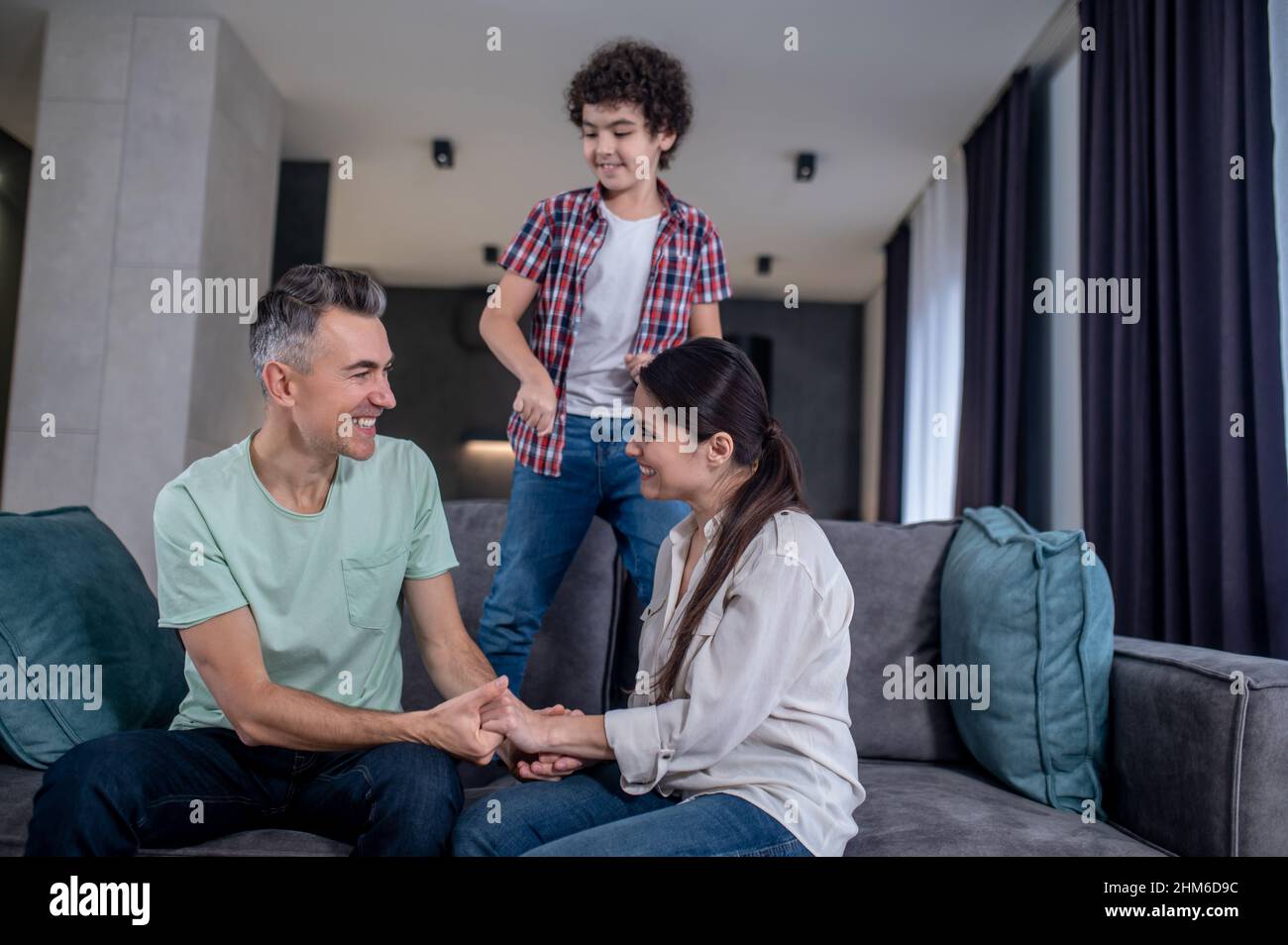 Mann und Frau halten die Hände seitlich zur Kamera sitzend Stockfoto