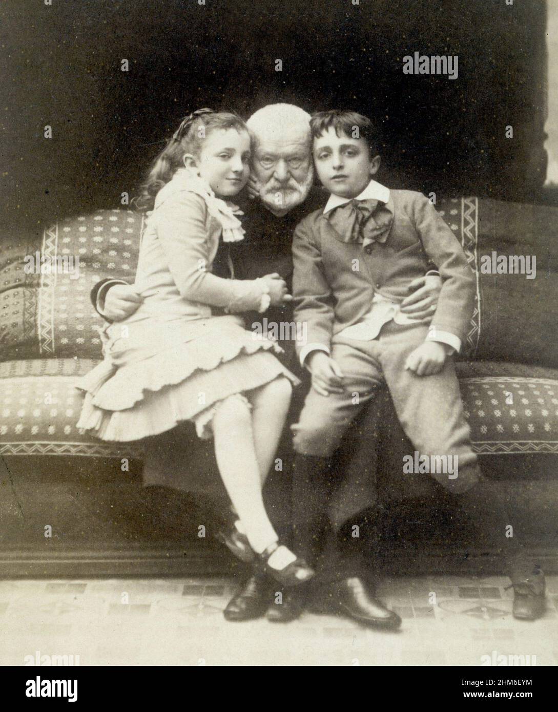 Ein Porträt des französischen Schriftstellers Victor Hugo, Autor von Les Misèrables, mit den Enkelkindern Jeanne und Georges. Das Foto stammt aus dem Jahr 1881, als er 79 war. Stockfoto