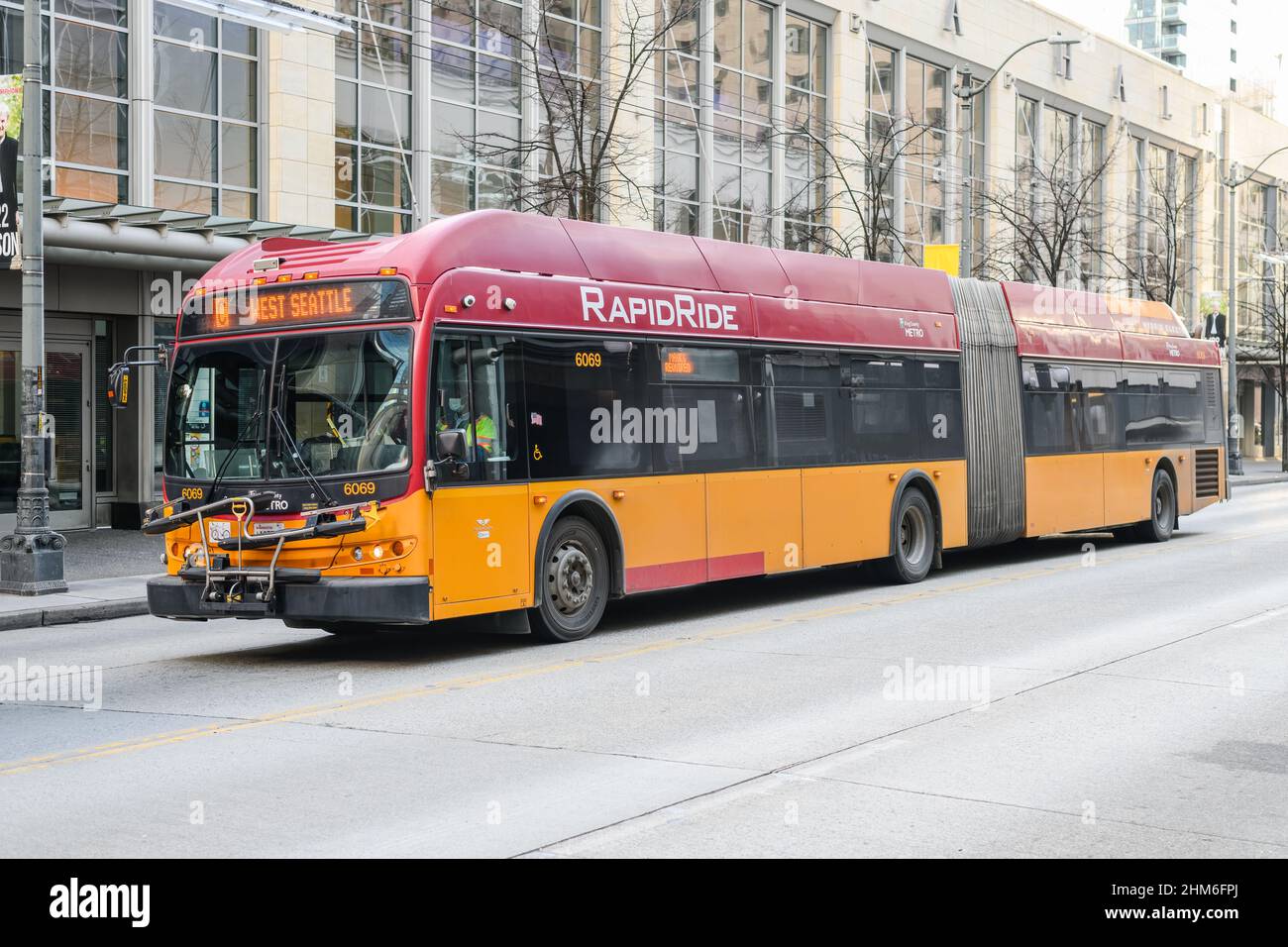 Seattle - 06. Februar 2022; King County Metro Hybrid-Elektrobus, der durch die Innenstadt von Seattle fährt und in RapidRide-Farben nach West Seattle fährt Stockfoto