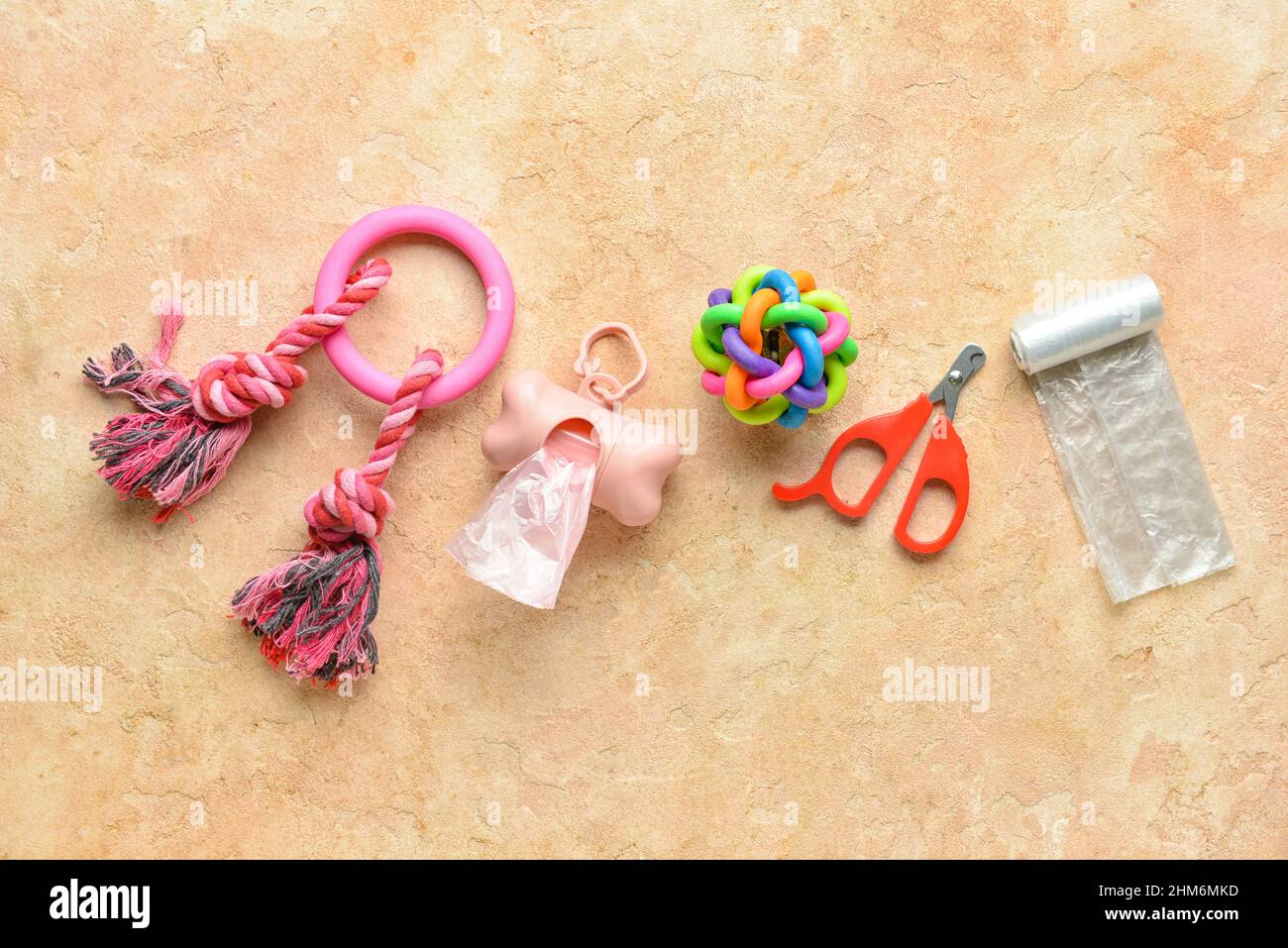 PET-Abfallbeutel, Nagelschneider und Spielzeug auf farbigem Hintergrund Stockfoto