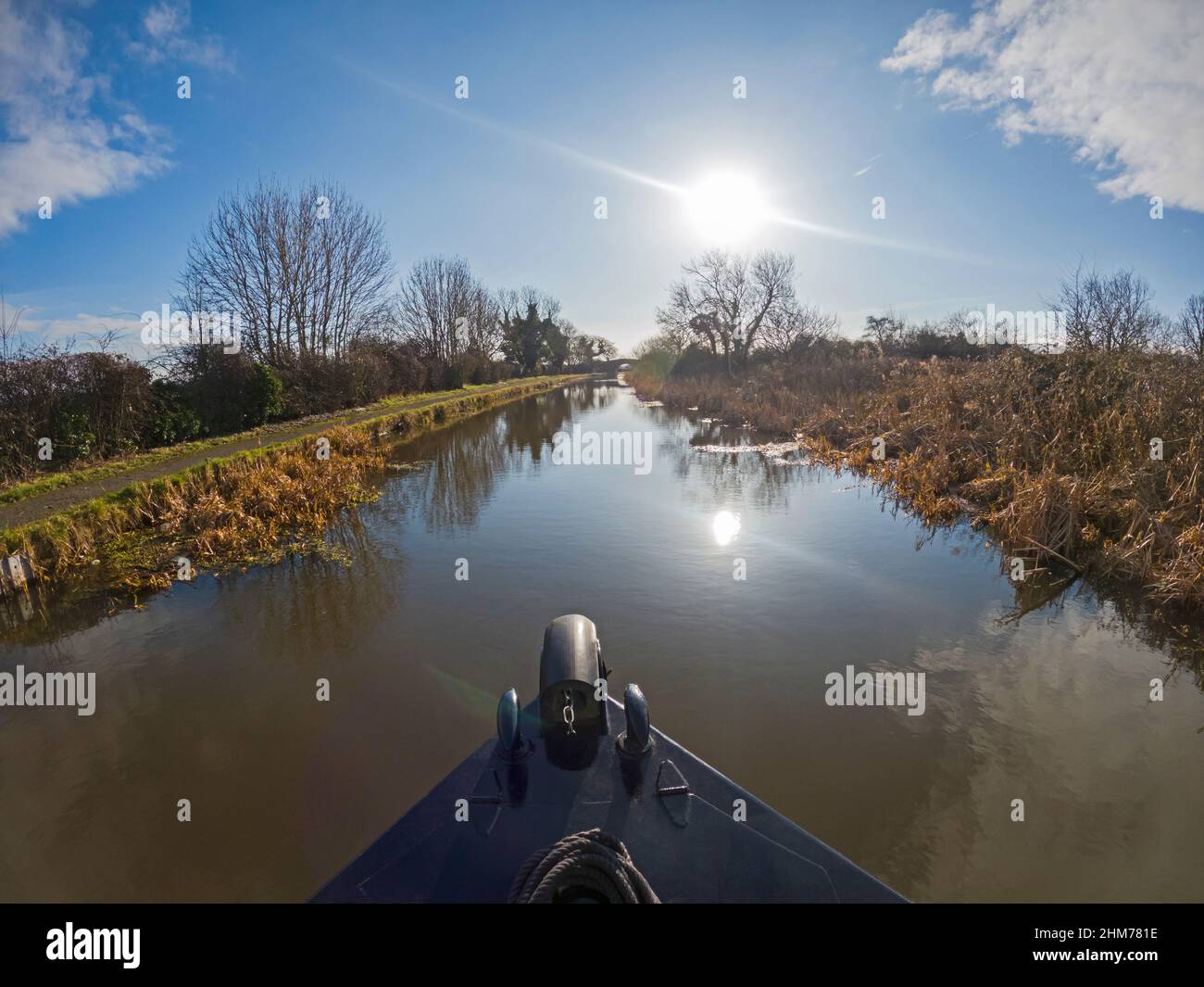 Blick vom Schmalboot Bogen auf die ländliche Landschaft Englands auf einem britischen Wasserstraßenkanal mit Sonneneinbruch und Wolken Stockfoto