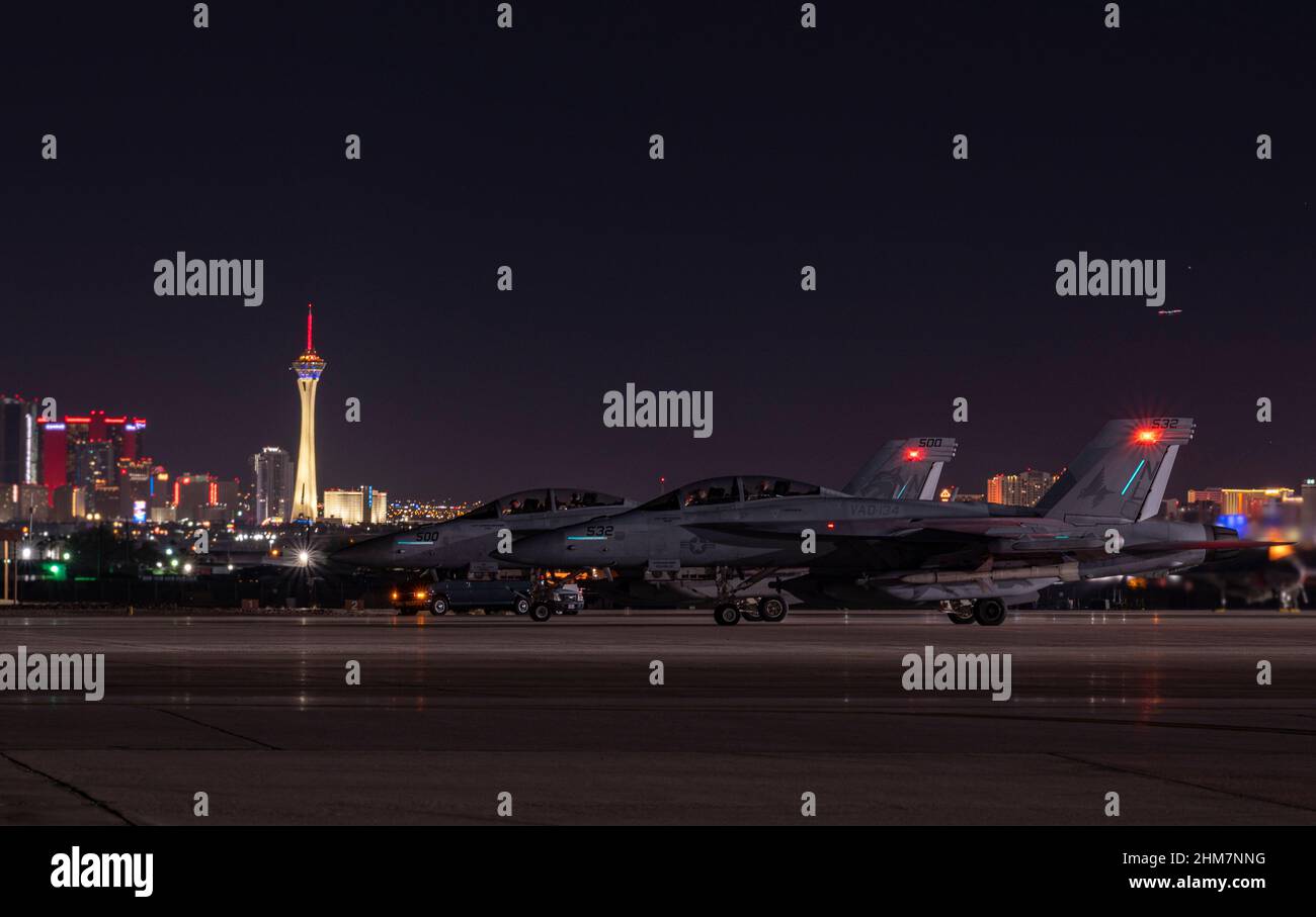 Zwei EA-18G Growler, die der Naval Air Station Whidbey Island, Washington, zugewiesen wurden, sitzen und warten auf den Start vor einer Mission mit der Roten Flagge Nellis 22-1 auf dem Luftwaffenstützpunkt Nellis, Nevada, am 1. Februar 2022. Die Teilnehmer führen eine Vielzahl von Szenarien durch, darunter defensive Gegenluft, offensive Gegenluftunterdrückung feindlicher Luftverteidigungen und offensive Gegenluft-Sperrungen. (USA Luftwaffe Foto von William R. Lewis) Stockfoto