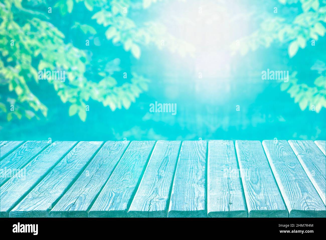 Leere alte Holztischplatte zur Produktanzeige auf unscharfem Parkhintergrund. Wunderschöne azurblaue Pastellfarben. Stockfoto