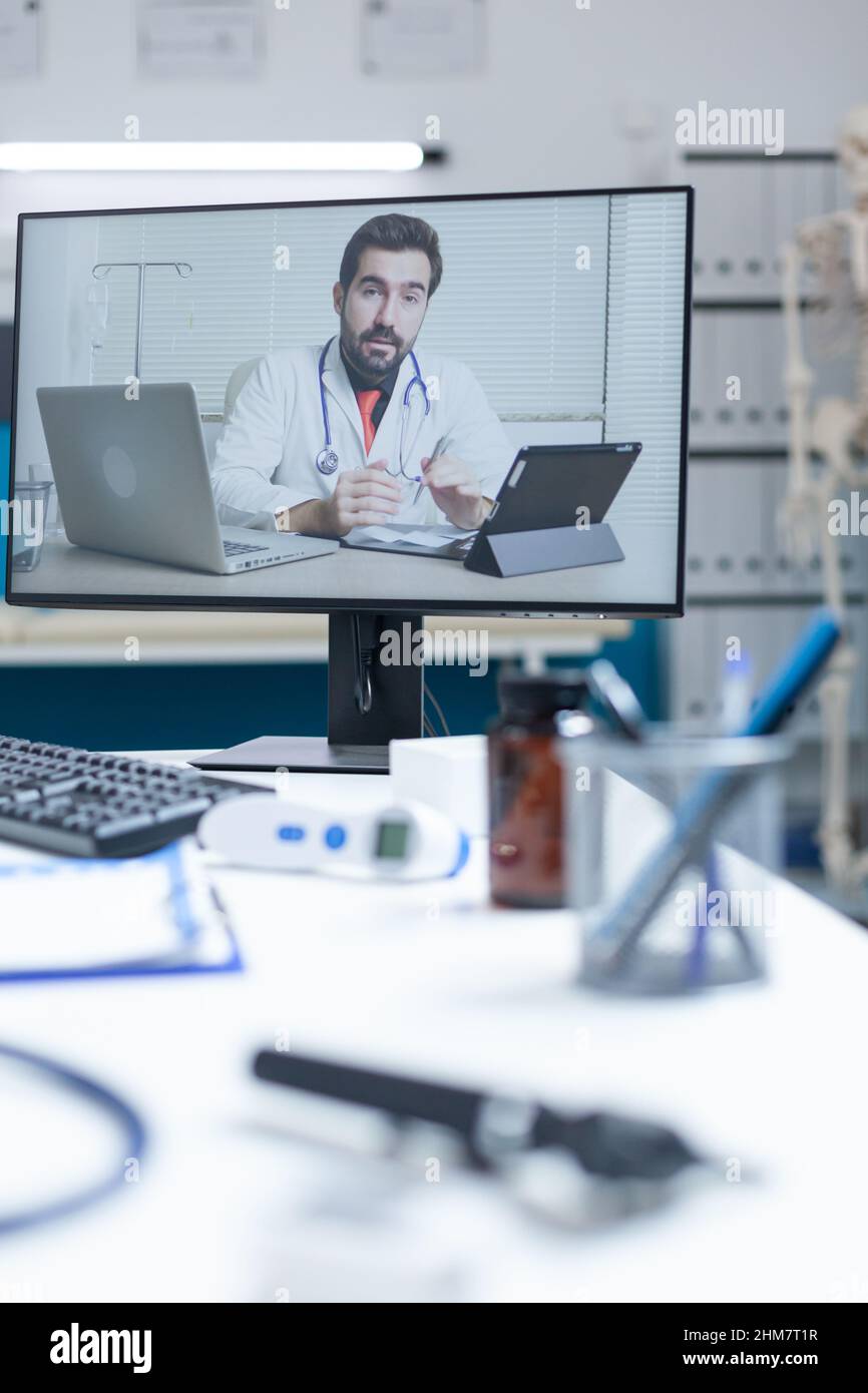 Leeres Krankenhausbüro mit Remote-Arzt, der während der Konferenz zur Telemedizin-Videokonferenz medizinische Online-Gespräche führt. Computer mit Videokonferenzanruf in Telearbeit auf dem Bildschirm. Unterstützung der Medizin Stockfoto