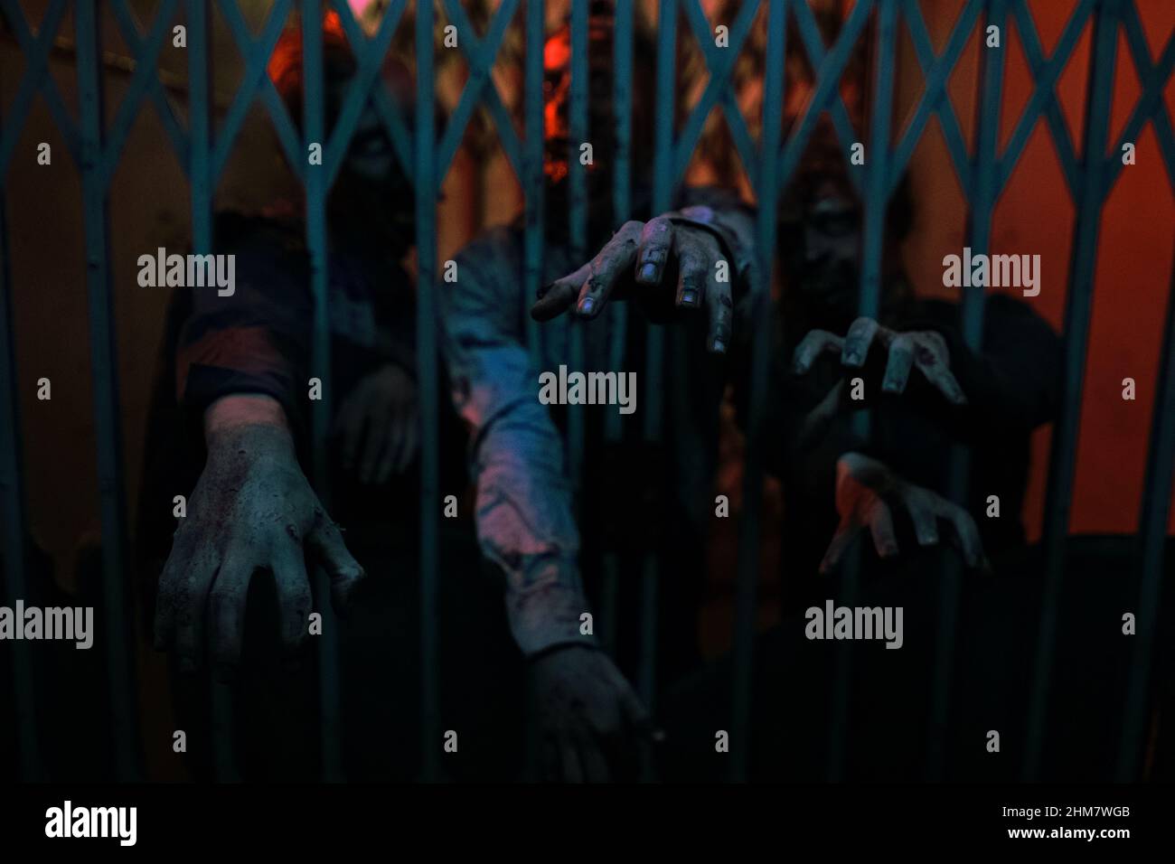 Nahaufnahme des Hintergrundbildes von Zombie-Händen, die durch die Tür im dunklen Flur greifen, Platz kopieren Stockfoto
