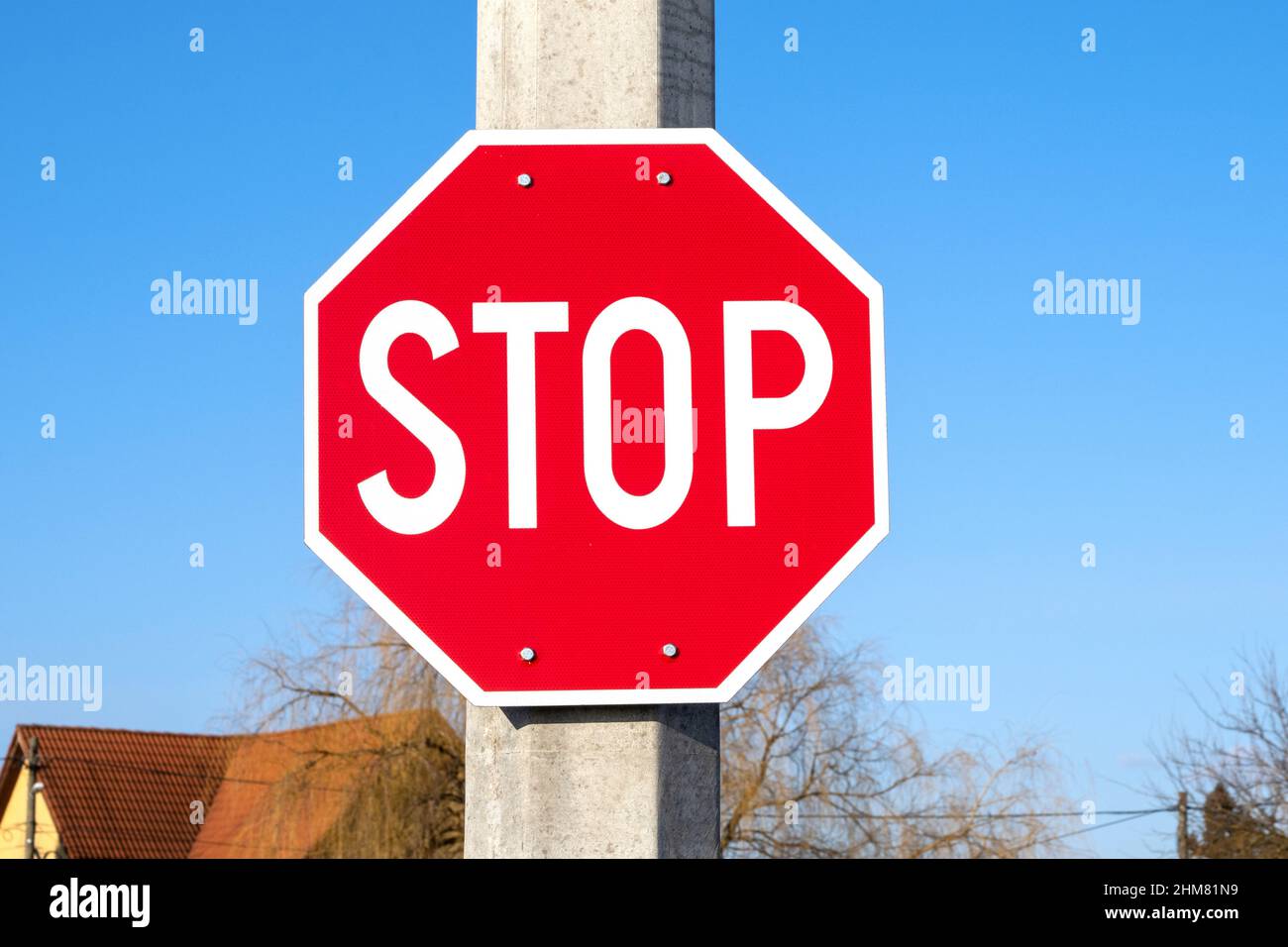 HALTEN Sie DAS rote Straßenschild an einer Säule in einer Straße AN Stockfoto