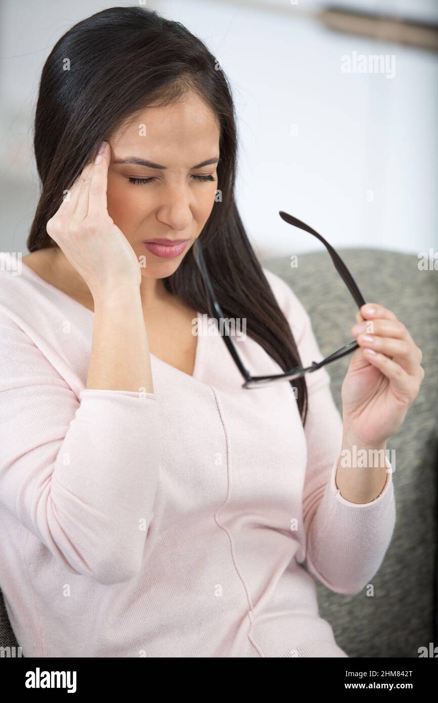Unglückliche Frau leidet unter Kopfschmerzen zu Hause Stockfoto