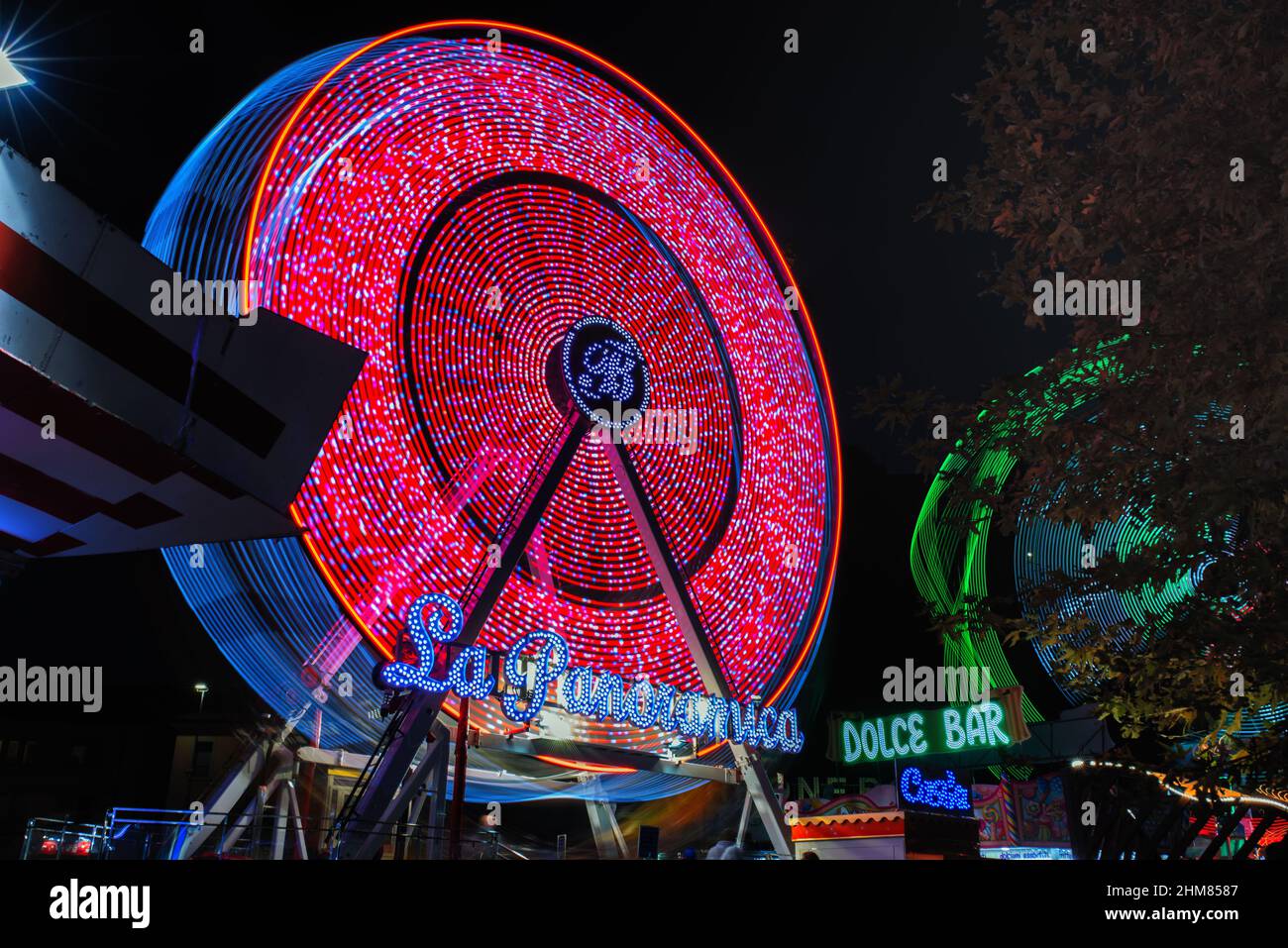 Panoramarad läuft im Dunkeln. Luna Park Attraktion. Langzeitbelichtung. Stockfoto