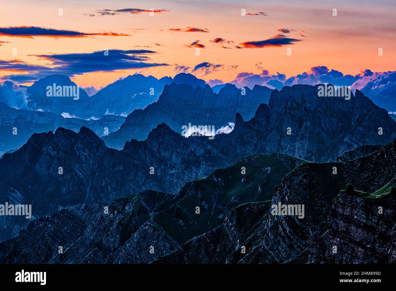 Silhuettes von Dolomitenkämmen und Gipfeln bei Sonnenaufgang, Civetta links in der Ferne, von oberhalb des Valles-Passes gesehen. Stockfoto