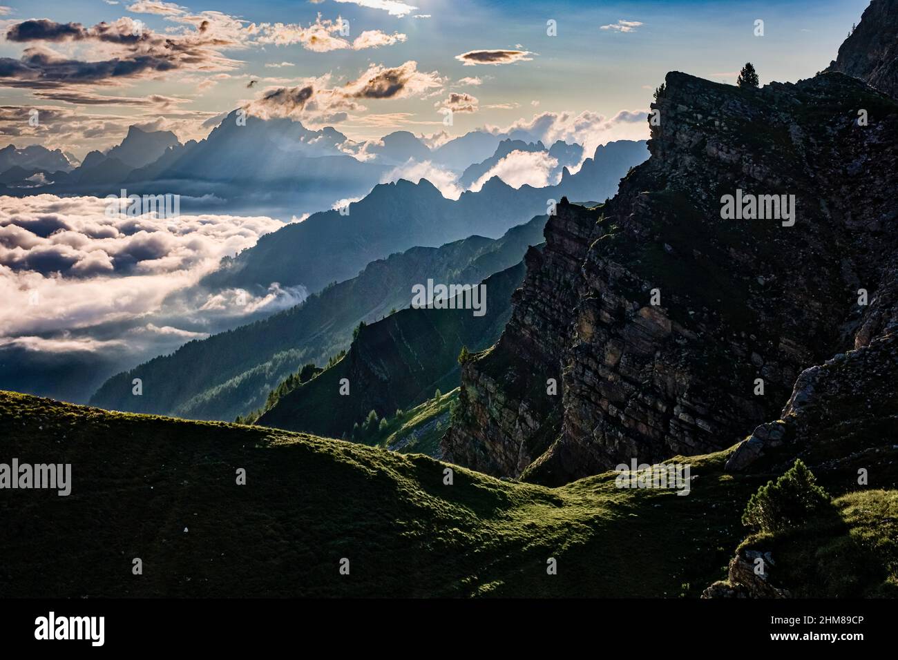 Dolomitenrücken und Gipfel rund um Falcade, bedeckt mit Wolken, im Biois-Tal, von oberhalb des Valles-Passes bei Sonnenaufgang gesehen. Stockfoto