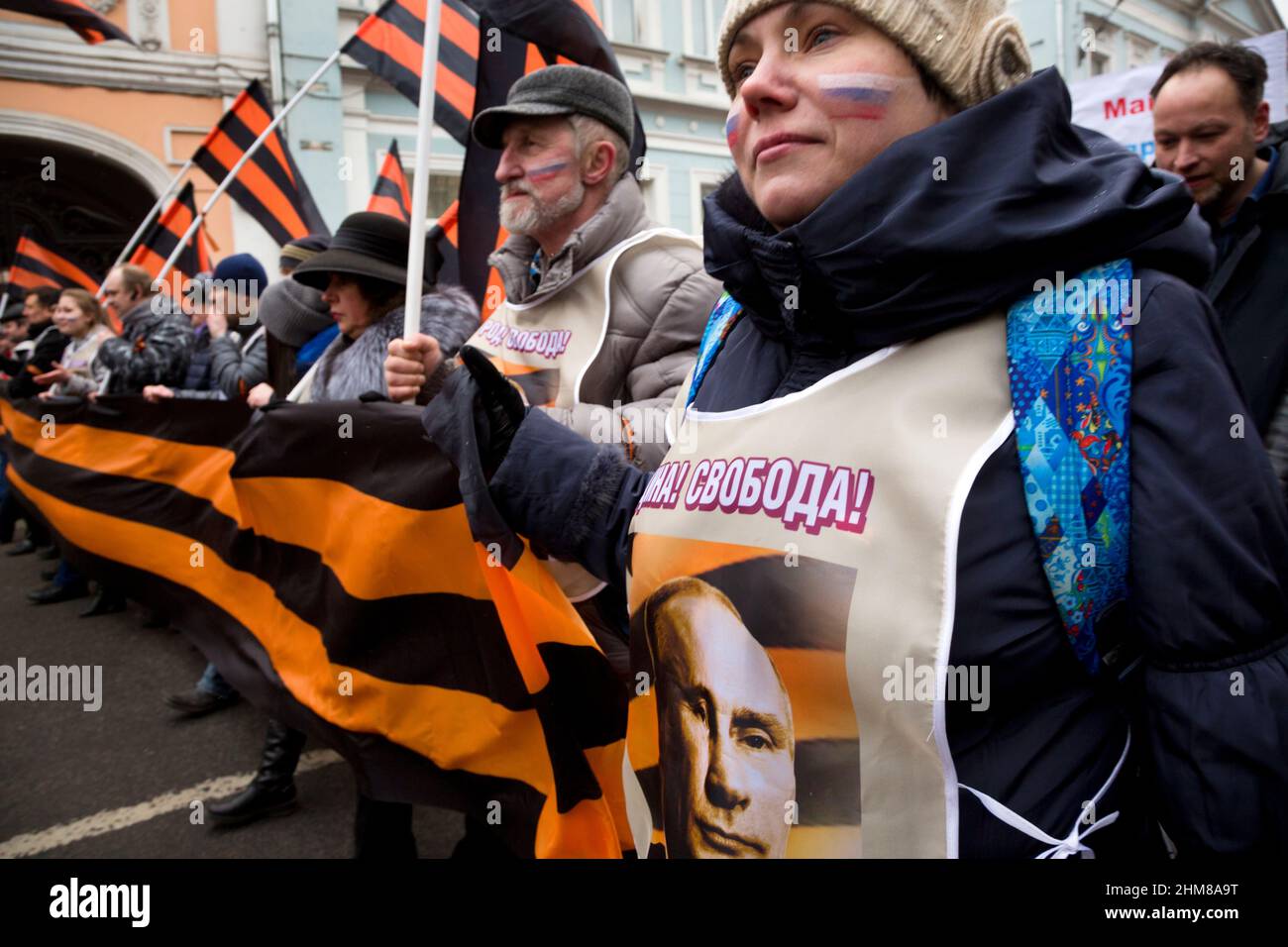 Moskau, Russland. 2nd. März 2014 Eine Frau mit einem St. George Band und einem Porträt von Präsident Wladimir Putin während des Marsches zur Unterstützung des ukrainischen Volkes und gegen die Machtergreifung in Kiew, im Zentrum von Moskau, Russland Stockfoto