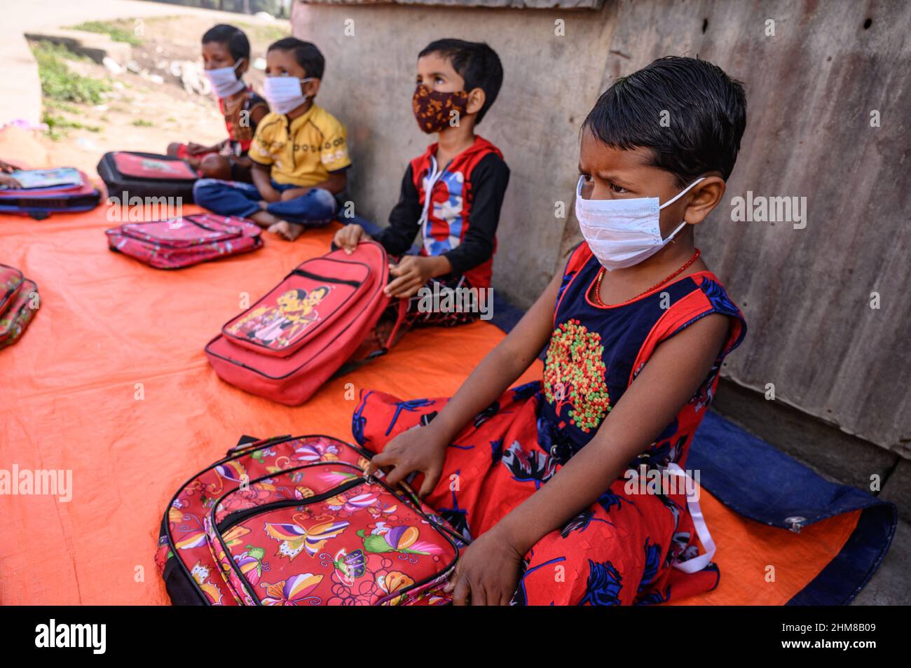 Die Regierung des Bundesstaates Westbengalen hat ‘Paray Shikshalaya’ vom 7th. Eine gemeindebasierte Schularbeit in Nachbarschaften, die sich an Grundschüler richtet, um die programmierten Ziele zu erreichen, besteht darin, einen großen Teil der Schüler zurückzuholen, die in den letzten zwei Jahren aufgrund der Schließung von Schulen aufgrund von Covid-19 aus dem formalen Bildungssystem ausgefallen sind. Die Vorschulklasse einer an der Grenze zwischen Indien und Bangladesch angrenzenden Grundschule wird auf einer leeren Straße neben dem Zaun bei Nabin Nagar durchgeführt, es kommen gelegentlich Haustiere. (Foto von Soumyabrata Roy/Pacific Press) Stockfoto