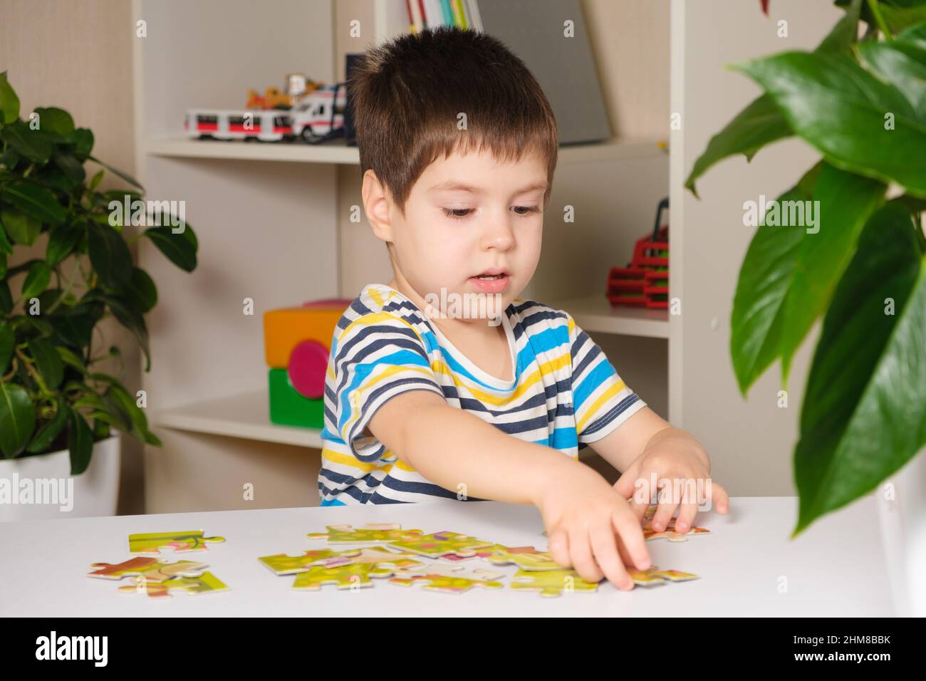 Ein Vorschulkinder spielt Puzzles, stellt ein Bild zusammen Stockfoto