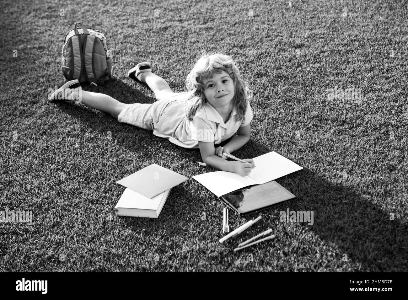 Kind las ein Buch. Kinderschule und Outdoor-Bildung. Natur und Park. Frühzeitiges Lernen. Sommer im Freien. Stockfoto