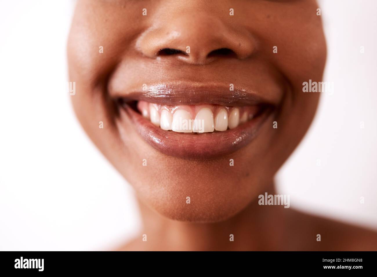 Ein Lächeln kann die Welt verändern. Studioaufnahme einer nicht erkennbaren Frau, die vor weißem Hintergrund lächelt. Stockfoto