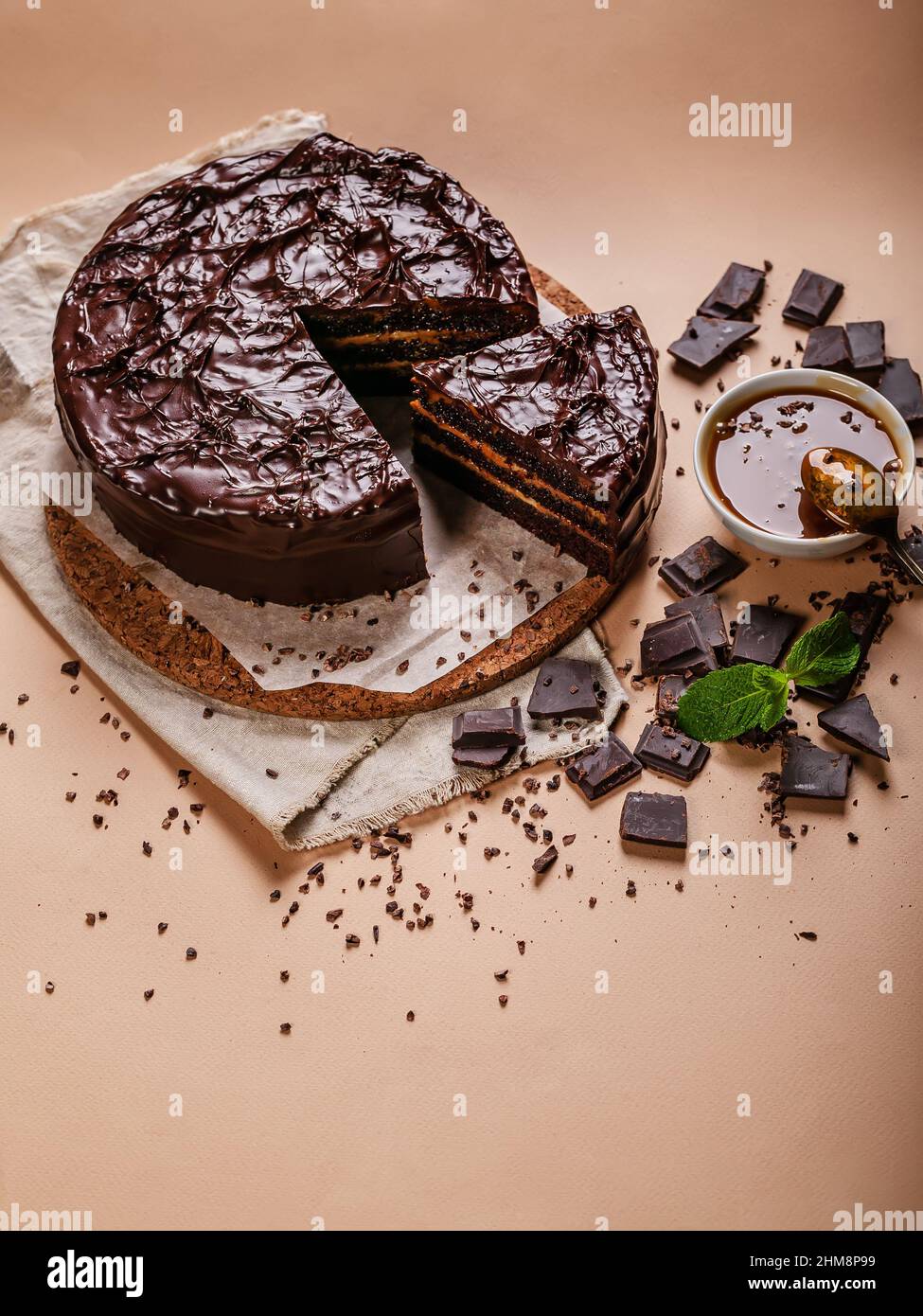 Schokoladenkuchen mit gesalzenem Karamell auf beigefarbenem Hintergrund. Hausgemachtes, köstliches Gebäck. Vertikale Aufnahme. Süßes Dessert. Speicherplatz kopieren Stockfoto