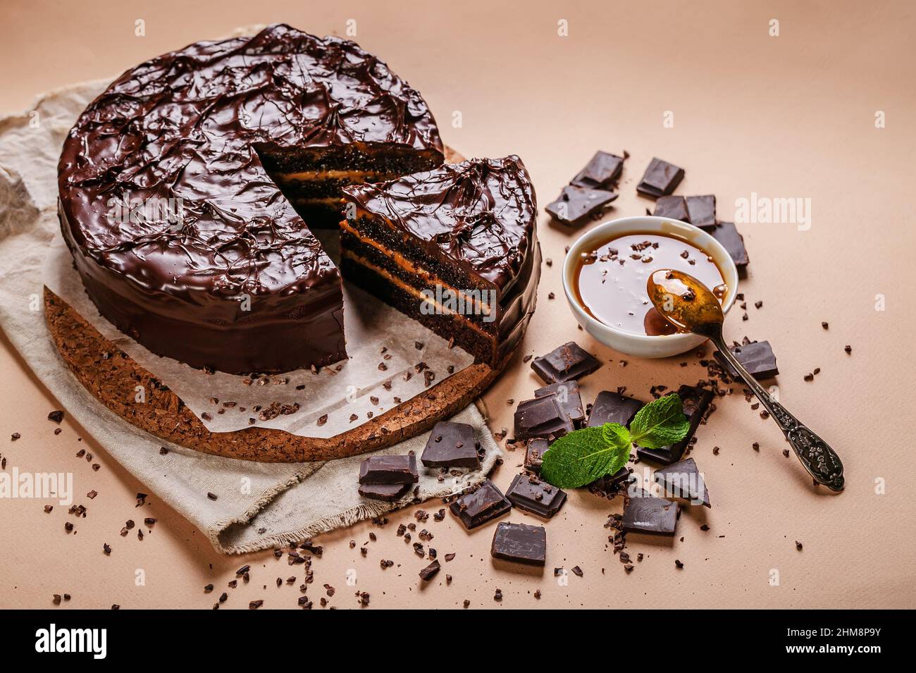 Draufsicht Schokoladenkuchen mit gesalzenem Karamell auf beigem Hintergrund. Hausgemachtes, köstliches Gebäck. Süßes Dessert. Stockfoto