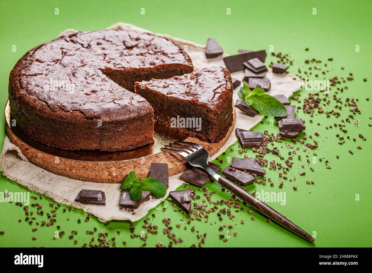 Klassischer Brownie-Schokoladenkuchen auf grünem Hintergrund. Hausgemachtes, köstliches Gebäck. Süßes Dessert. Nahaufnahme Stockfoto