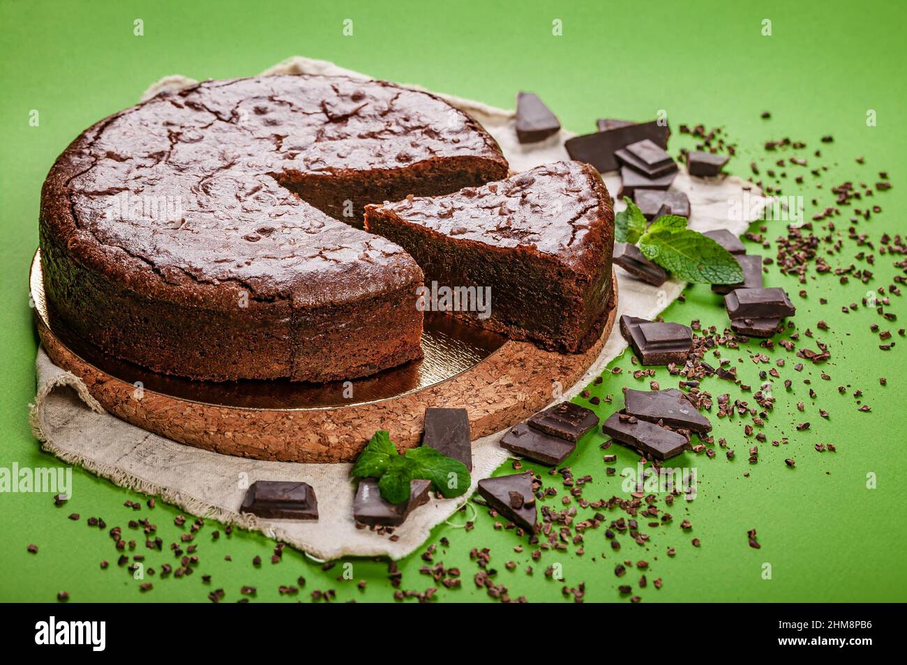 Klassischer Brownie-Schokoladenkuchen auf grünem Hintergrund. Hausgemachtes, köstliches Gebäck. Süßes Dessert. Speicherplatz kopieren Stockfoto