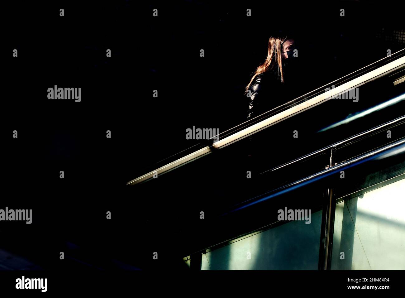 Frau, die die U-Bahn mit der Rolltreppe verlässt, Barcelona. Stockfoto