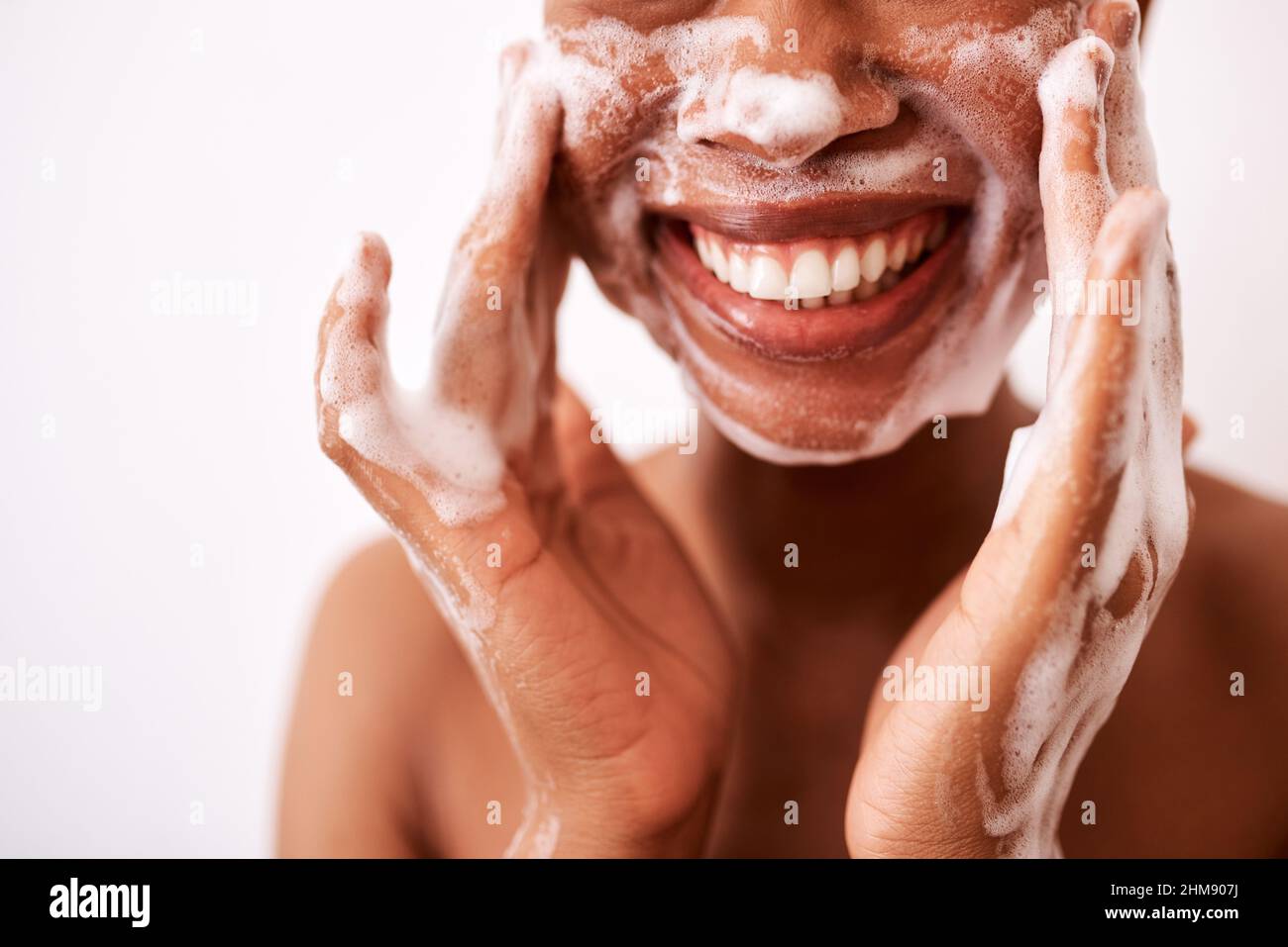 Ich wasche mein Gesicht zweimal am Tag. Studioaufnahme einer unkenntlichen Frau, die ihr Gesicht vor weißem Hintergrund wäscht. Stockfoto