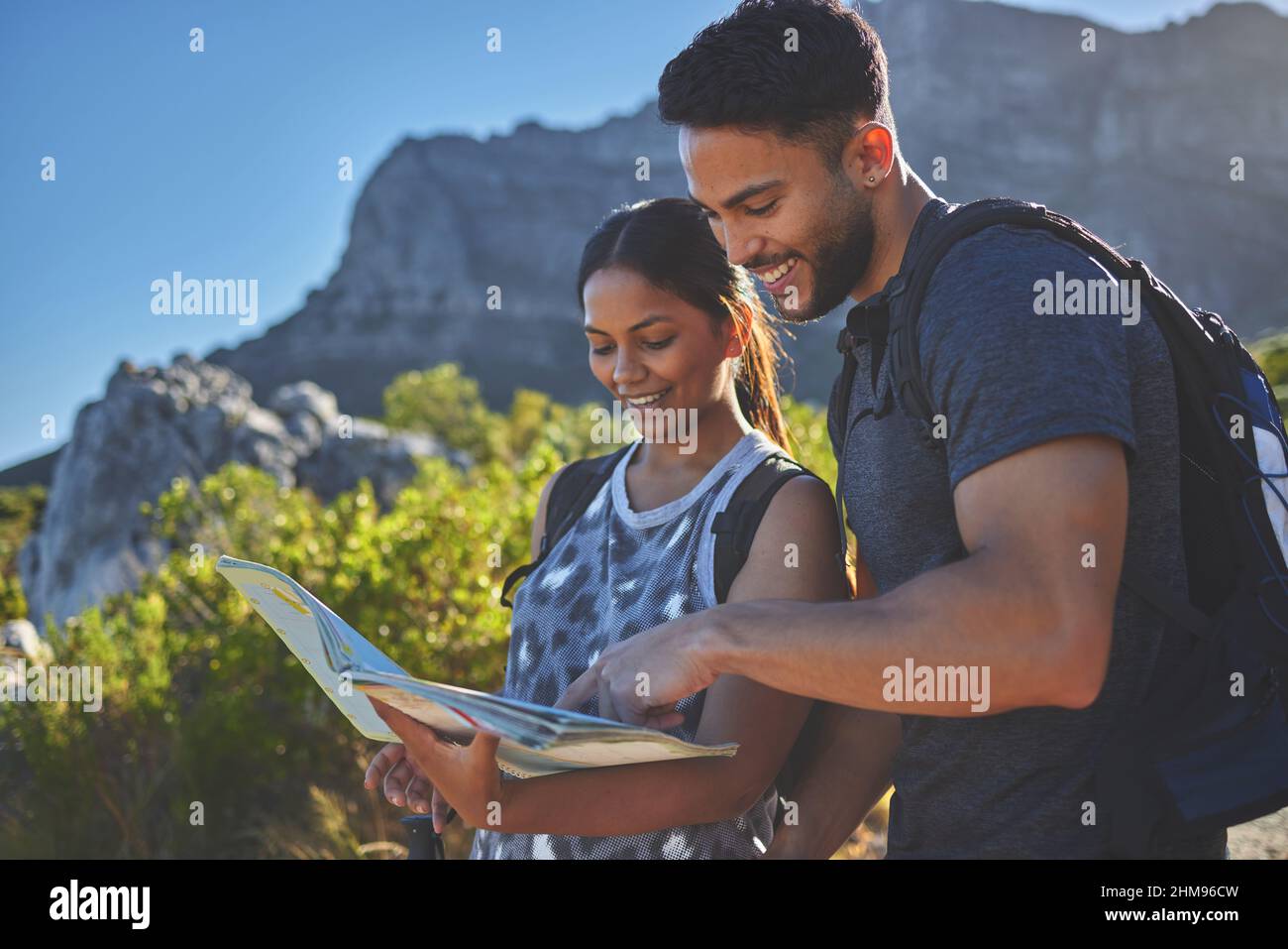 Wir müssen sicherstellen, dass wir uns hier nicht verlaufen. Aufnahme eines jungen Paares mit einem Reiseführer, um eine Wanderung in einer Bergkette zu absolvieren. Stockfoto