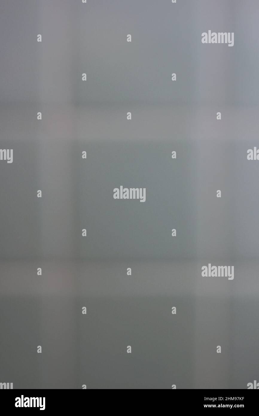 Hellgrüne quadratische Fliesen mit weißem Mörser und Linien in verschwommenem Bokeh. Stockfoto