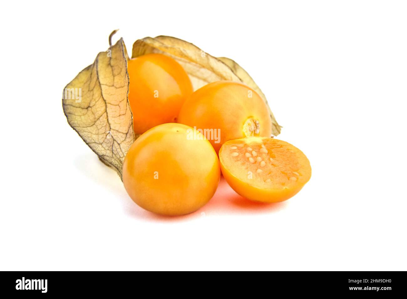 Physalis peruviana Beeren, halbierte reife Früchte, ganze und halbierte Goldbeeren mit trockenen Blättern (Erdkirschen, Kapgansbeere, Husktomaten) Stockfoto