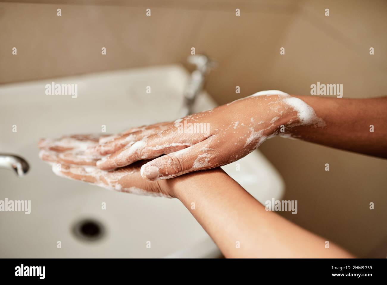 Was auch immer Sie tun, waschen Sie Ihre Hände. Ein kurzer Schuss einer Frau, die sich zu Hause im Waschbecken im Badezimmer die Hände mit Seife wäscht. Stockfoto