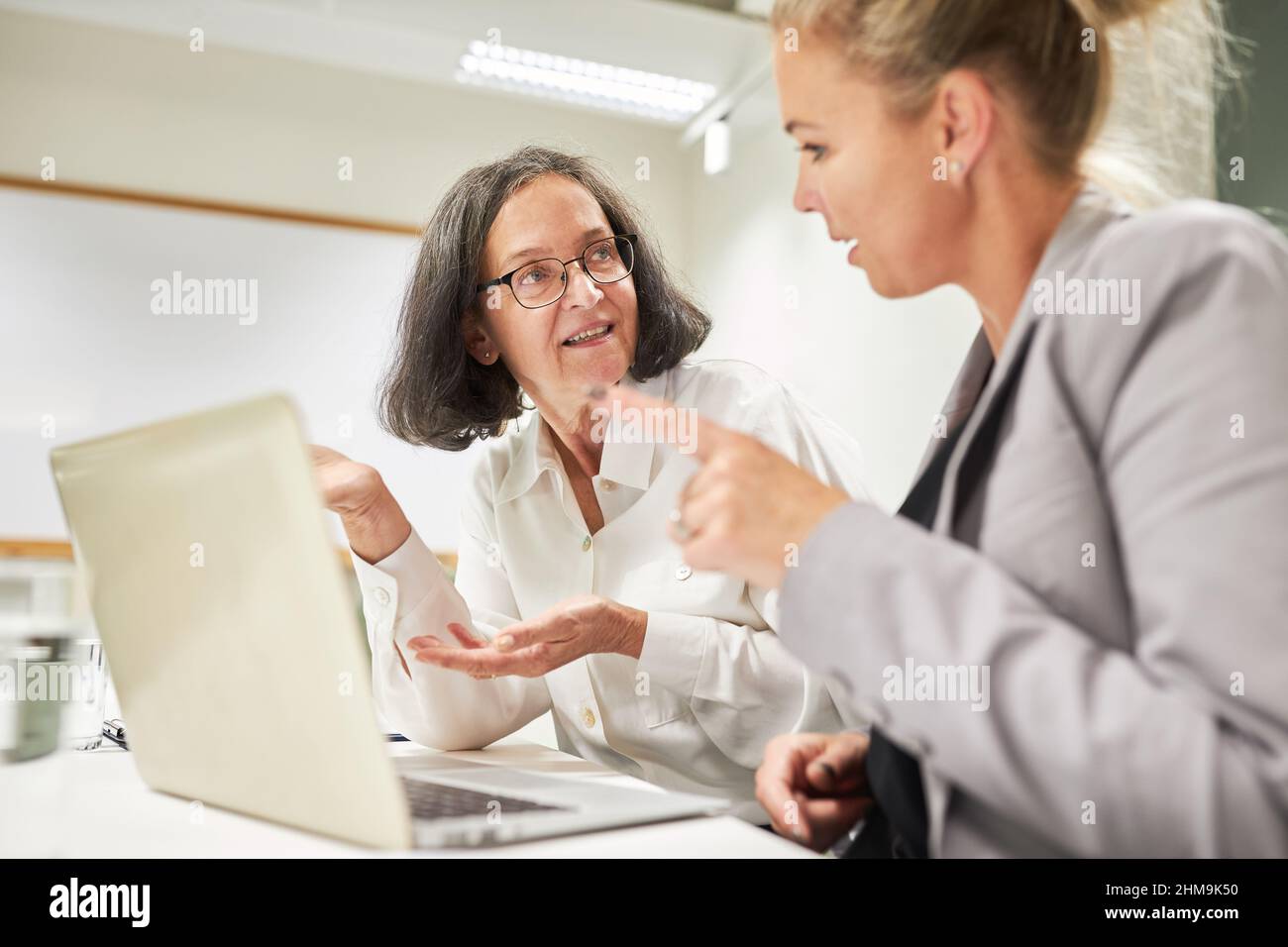 Zwei Geschäftsfrauen mit Tablet-Computern diskutieren im Büro über Strategie- und Projektplanung Stockfoto