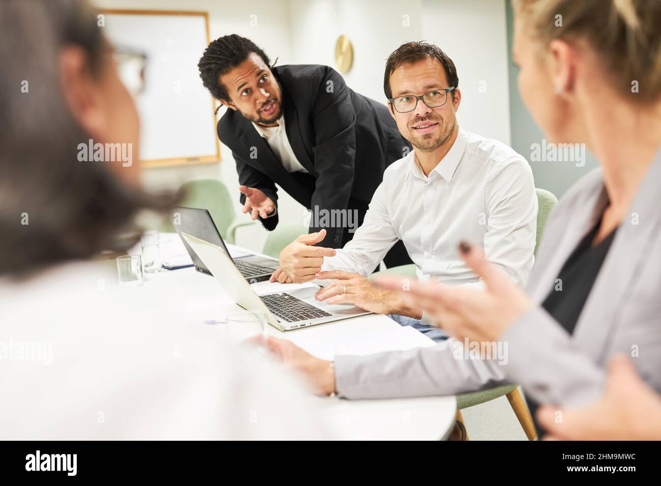 Mitarbeiter des Geschäftsteams mit Computern besprechen Projektplanung und -Strategie bei der Besprechung im Büro Stockfoto