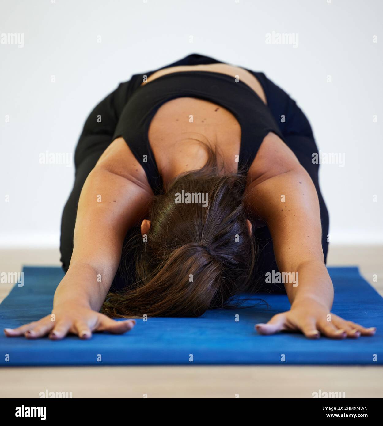 Yoga wird dein Leben verändern und wie du es lebst. Aufnahme einer jungen Frau, die zu Hause Yoga praktiziert. Stockfoto