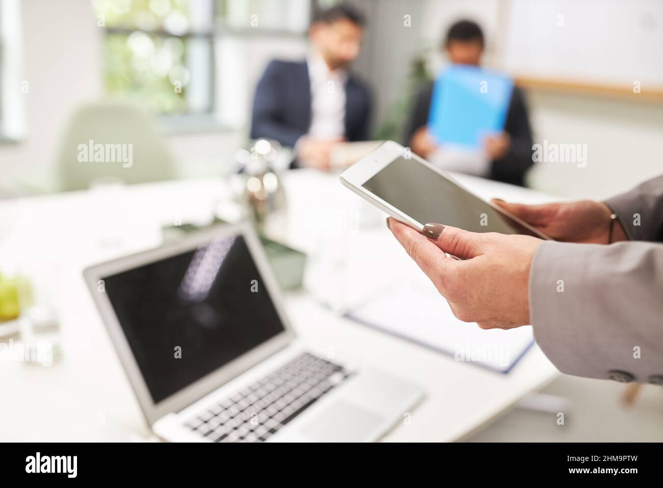 Geschäftsfrau, die im Konferenzraum im Büro Tablet-Computer und Laptop-pc online nutzt Stockfoto