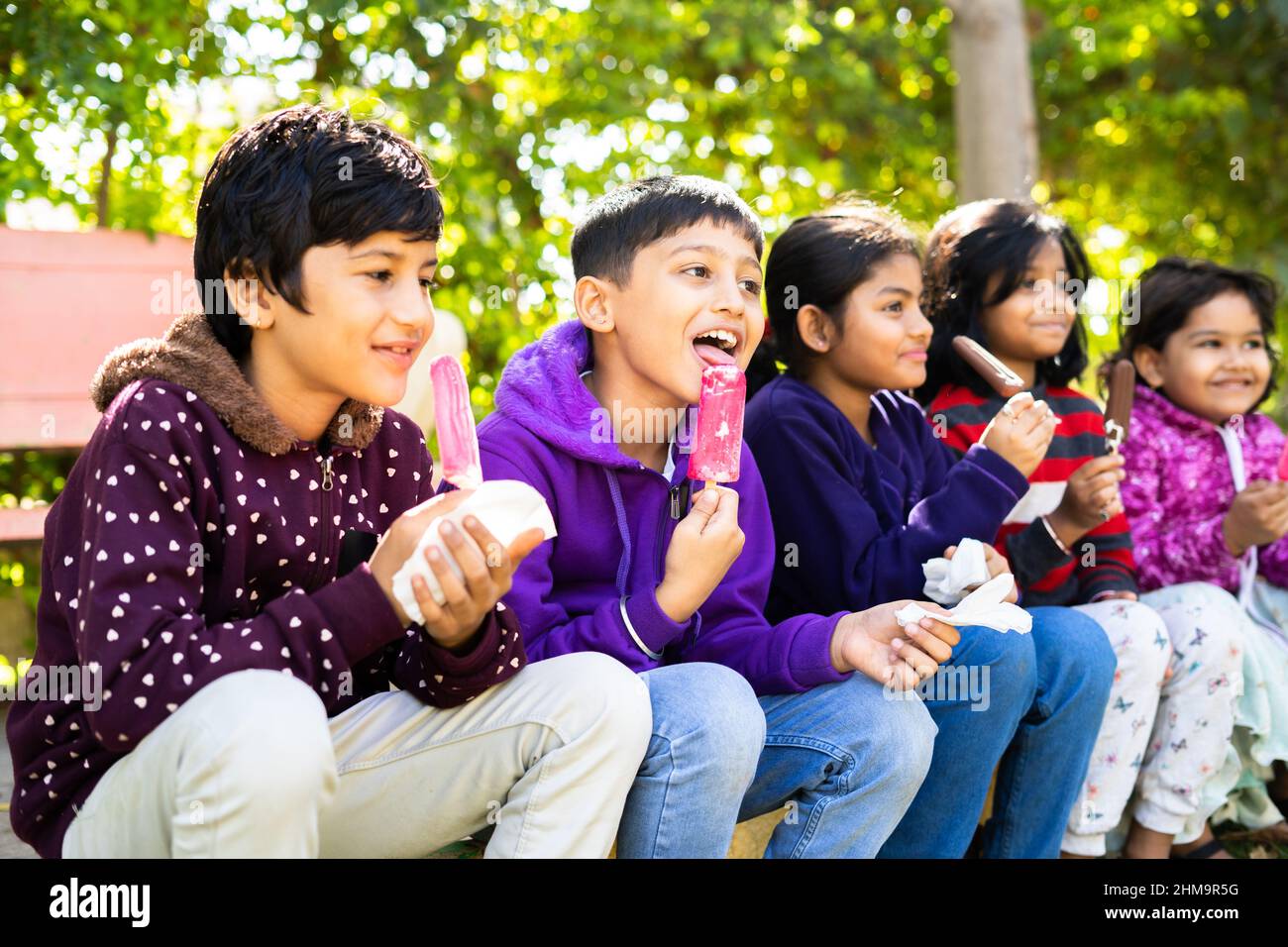 Indische Teenager-Kinder genießen Eis im Park - Konzept der Entspannung, Freundschaft, gesunde Ernährung und genießen Winterurlaub. Stockfoto