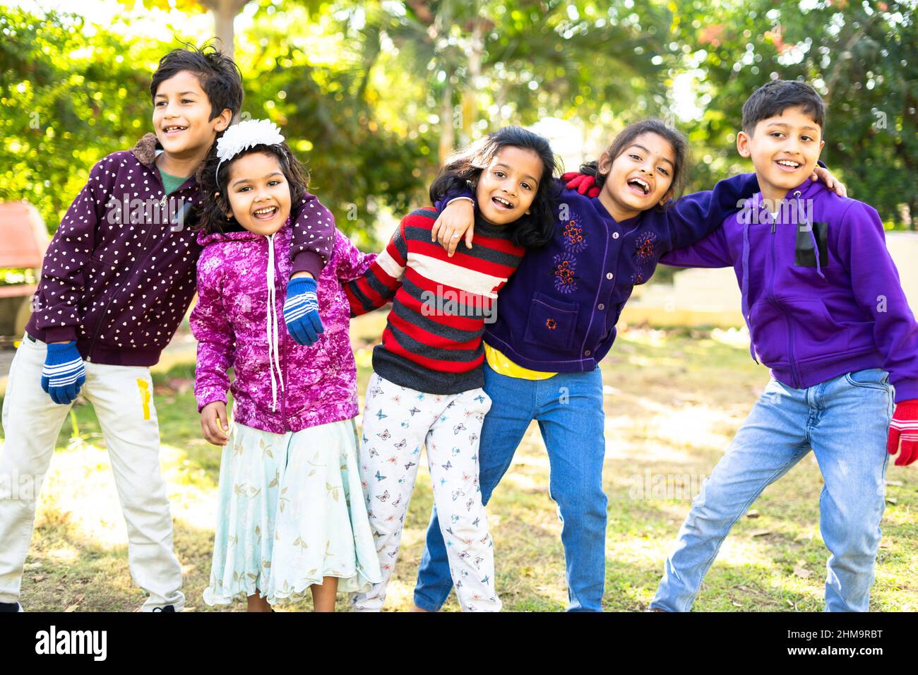 indische Teenager-Kinder genießen oder verbringen Zeit mit Freunden beim Tanzen im Park - Konzept der Feier, Picknick, Winterurlaub und Freizeitaktivitäten Stockfoto