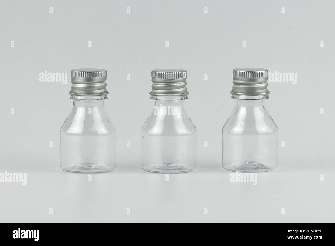 Transparente Glas kleine Flaschen isoliert für Ihren Text und Design. Unbranded transparentes Glas kleine Flaschen isoliert Vorlage Kopieplatz Stockfoto