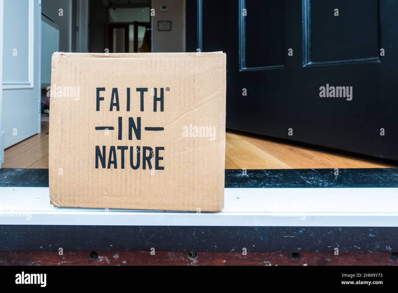 Faith in Nature Naturschönheitsprodukte werden in einem Karton vor der Haustür geliefert Stockfoto