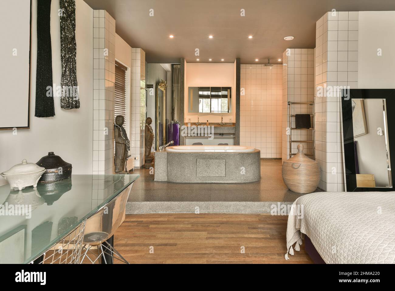 Modernes, offenes Badezimmer mit Keramikbadewanne und Schlafzimmer mit  komfortablem Bett in der Nähe des Fensters in einem hellen Apartment  Stockfotografie - Alamy